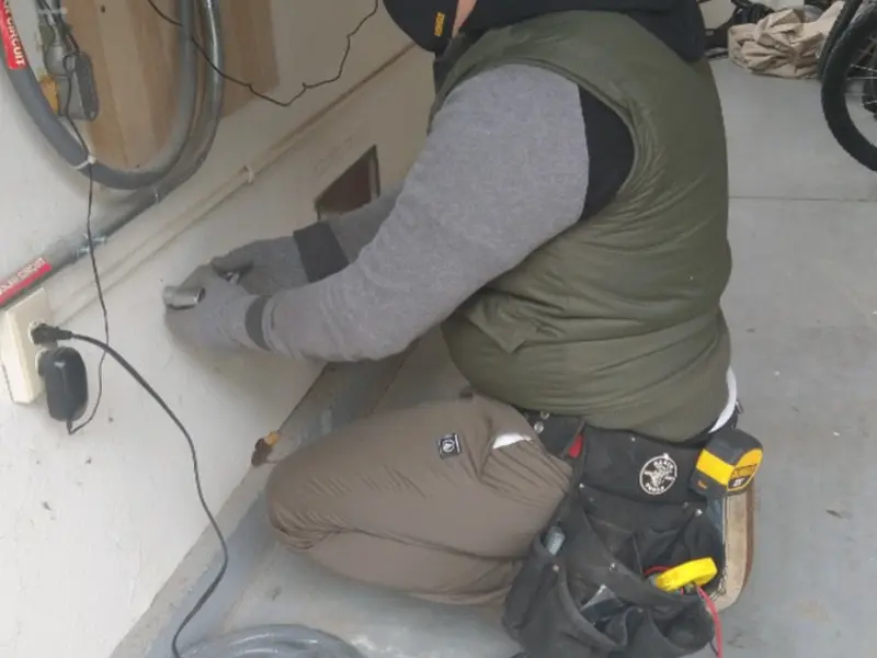 Electrician performing outlet wiring in a Millcreek garage